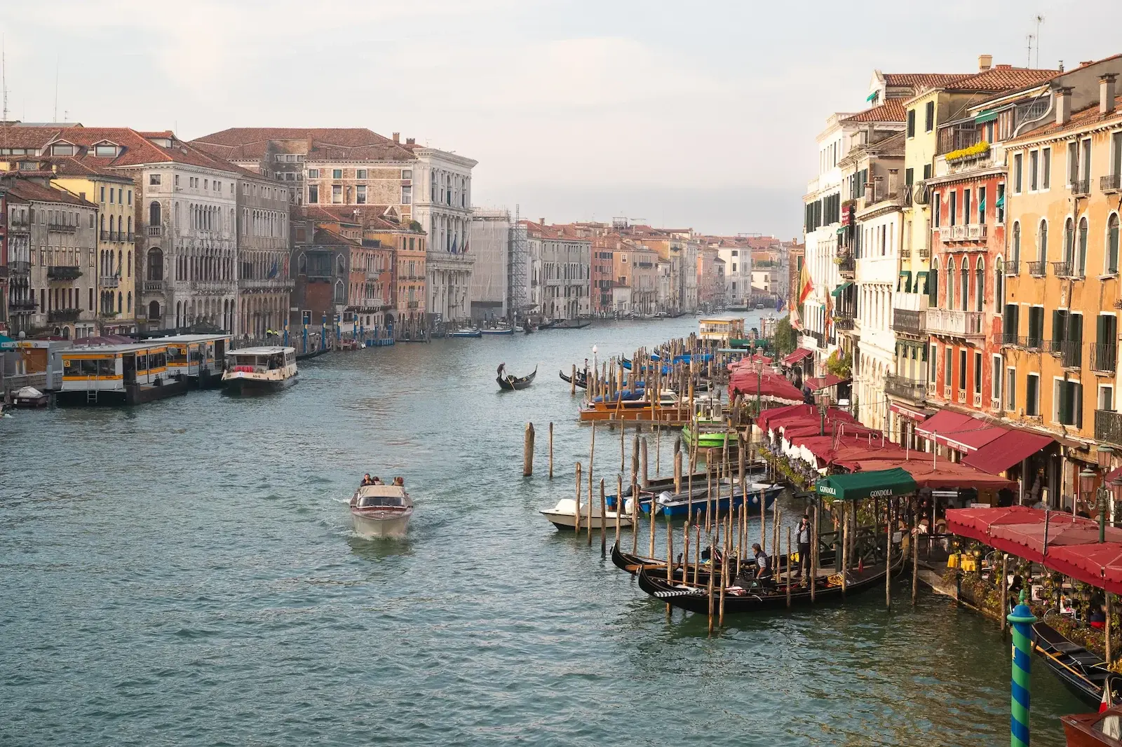 A big canal with buildings at each and boats.